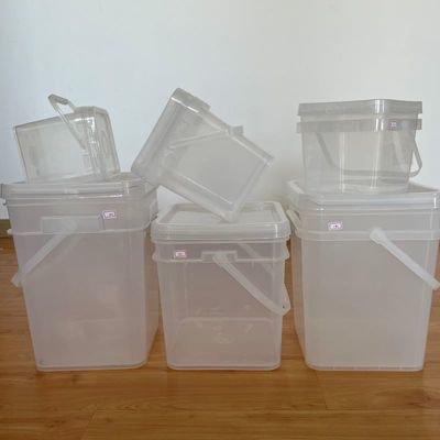 Un seau carré pour le stockage des graines avec un design transparent et une poignée de couvercle pratique